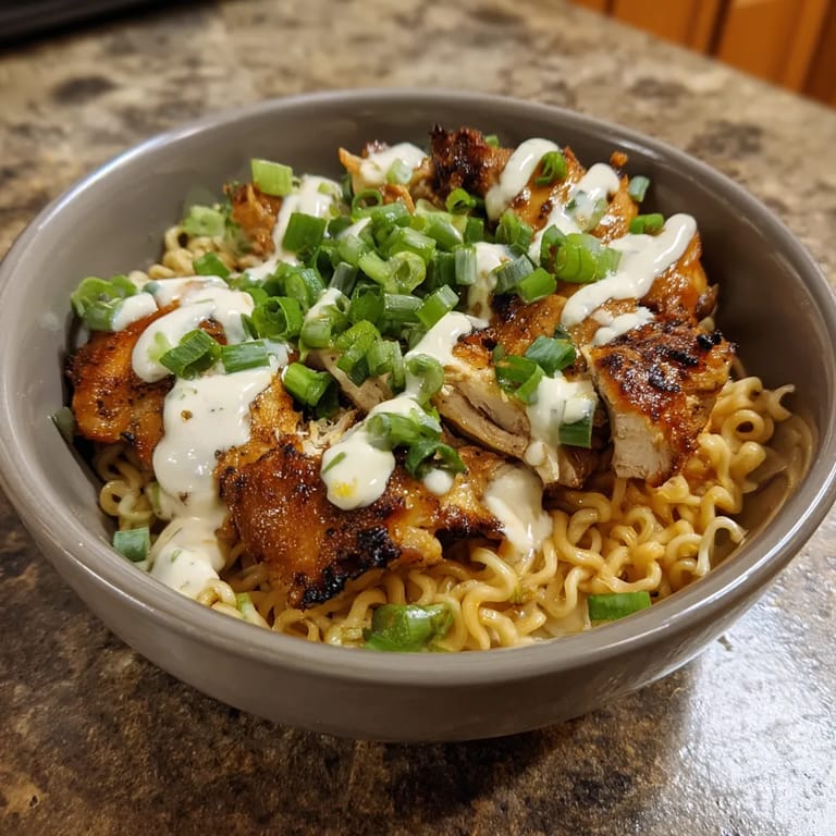 A bowl of chicken with noodles and vegetables.