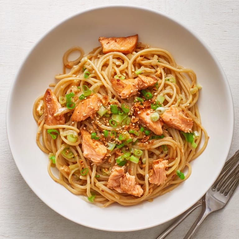 Delicious Japanese pan-fried salmon pasta served with lemon wedges for added zest.  