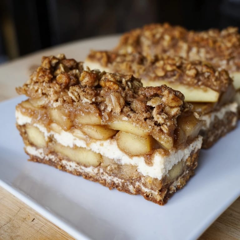 Golden-brown Apple Crisp Cheesecake Bars, a delicious dessert with a warm, spiced apple filling ready to enjoy.