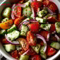 A bowl of cucumber tomato salad.