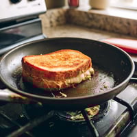 A grilled cheese sandwich on a stove.
