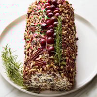 A decadent Yuletide Log cheese centerpiece, festive and ready to serve with crackers and veggies.