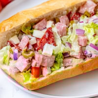 Pile of the savory Chopped Italian Grinder Sandwich, with golden toasted roll and fresh fillings.